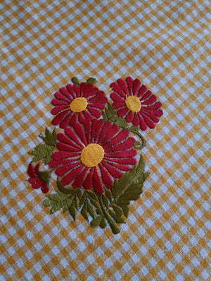 Floral embroidered table cloth in mustard gingham print